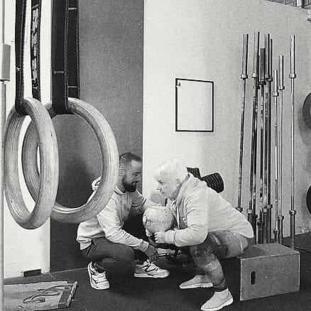 Mat Harvey coaching a member on the rings at the gym